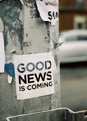 Ein auf eine Wand geklebter Zettel mit der Aufschrift Good News is coming als Hinweis zum Newsletter